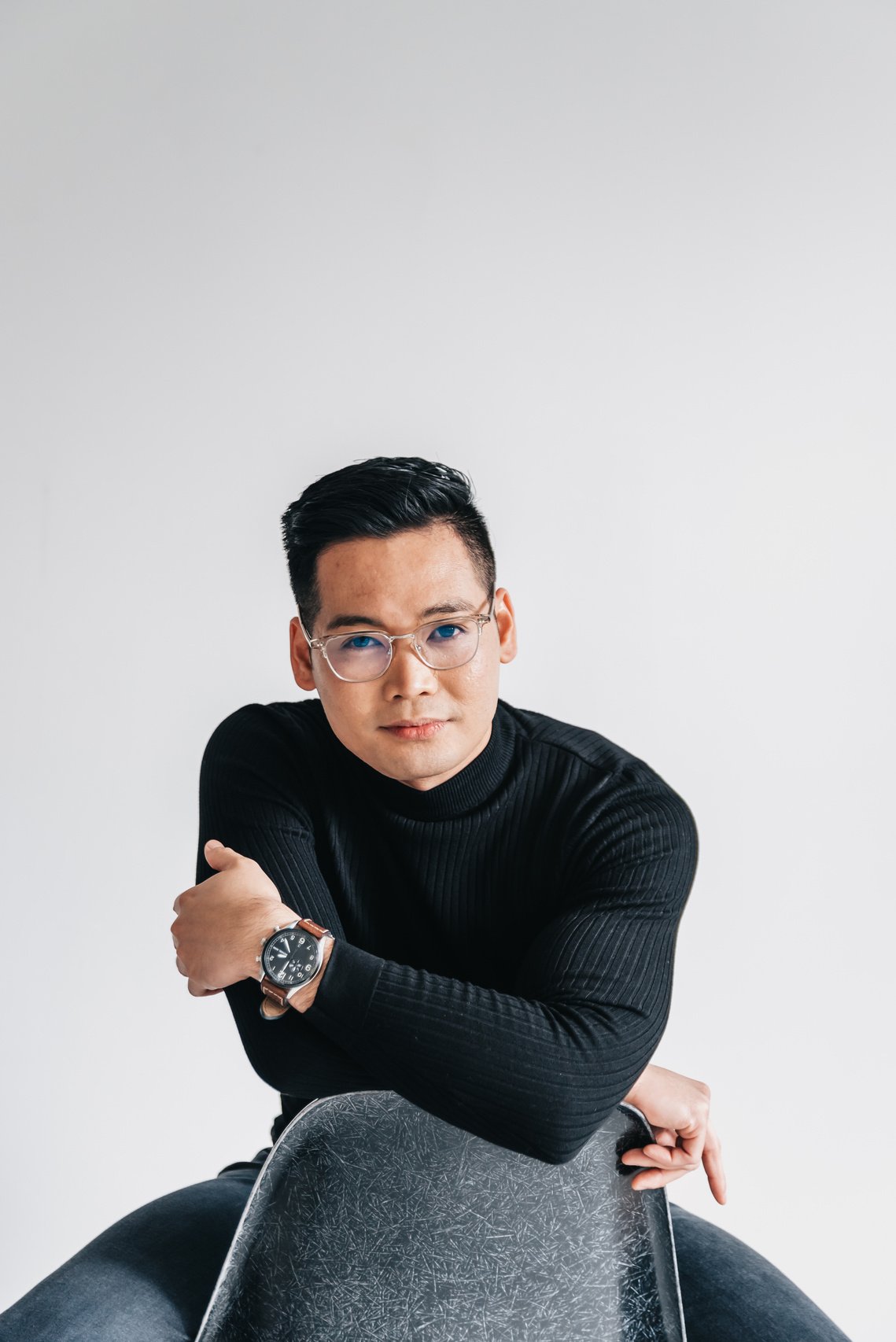 A Man in a Black Sweater Sitting on a Chair 